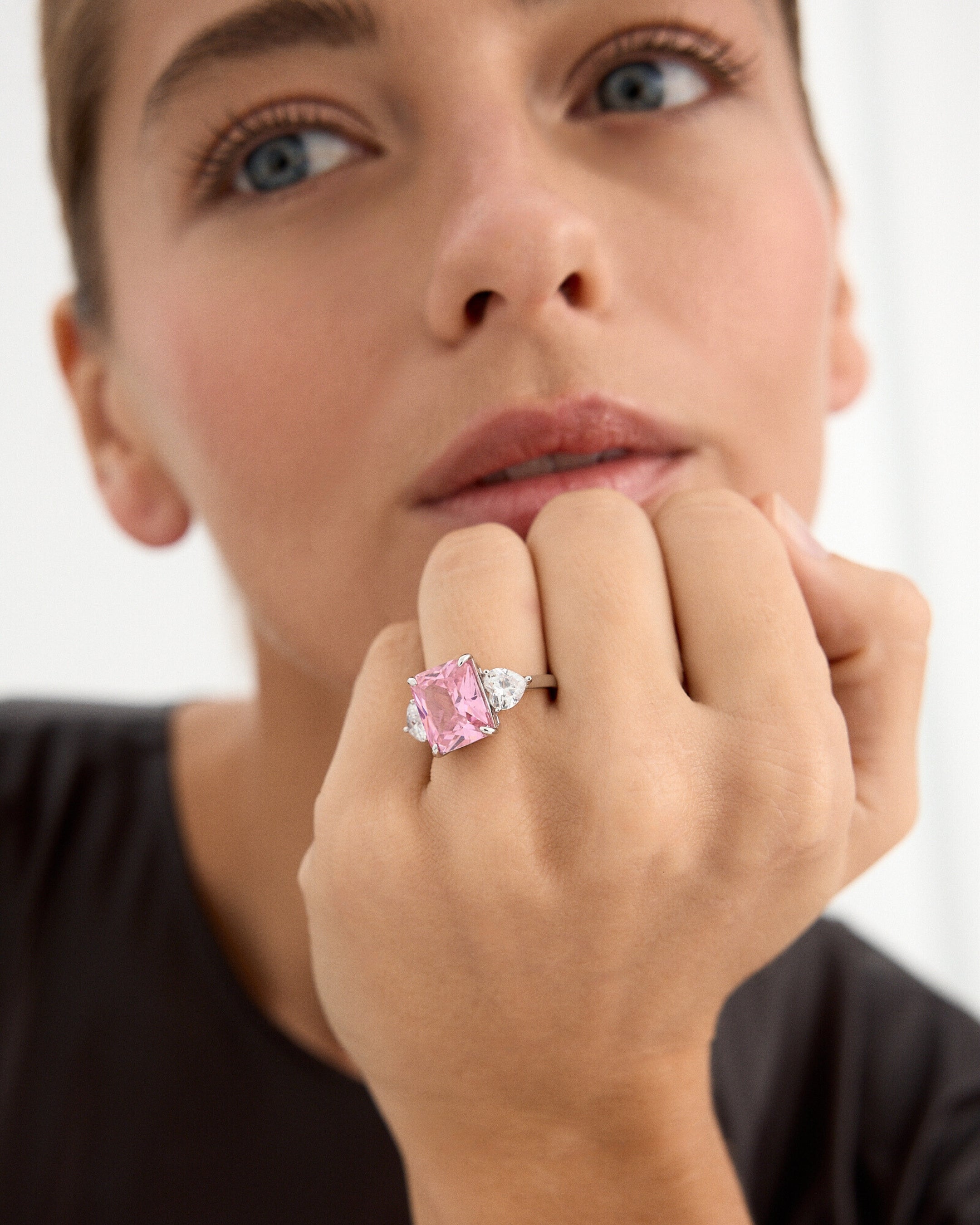 El anillo Caliche deslumbra en esta imagen, mostrando su elegante diseño en toda su majestuosidad. La gema central, en un encantador tono rosa morganita y tallada en estilo princesa, se convierte en el protagonista absoluto, irradiando un brillo delicado y romántico. Flanqueada por dos gemas en forma de corazón en los laterales, su sutileza y elegancia añaden un toque de pureza y distinción. La plata de Primera Ley 925, con un acabado en baño de rodio, realza el esplendor de cada detalle, logrando un acabad