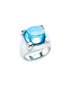 En la imagen se muestra el Anillo Solara, una pieza refinada en plata de ley 925 con acabados en oro amarillo o blanco. La joya centra un topacio natural en cabochón oval, resplandeciente en tonos azul celeste, perfecto para destacar en cualquier evento especial y añadir un toque de elegancia clásic